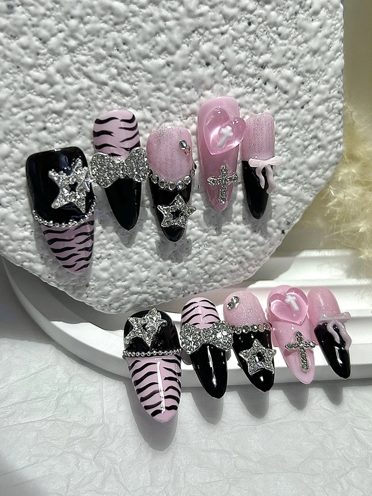 A set of glitter diamond press on nails featuring black, pink, and zebra print designs.
