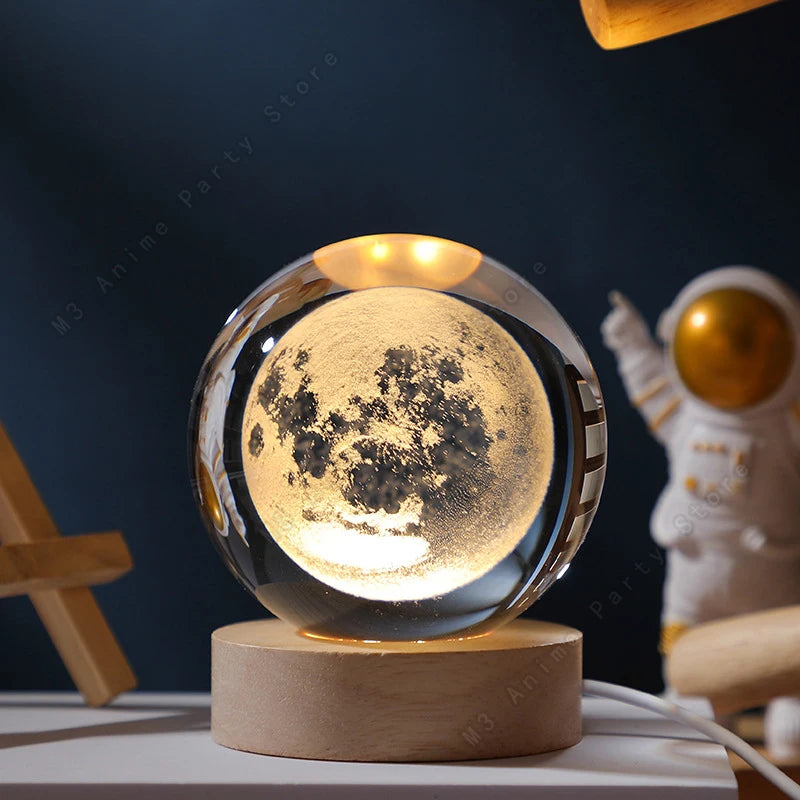 A glass crystal ball night light illuminates a detailed moon surface on a wooden base.