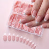 A set of pink and white glossy press-on acrylic nails displayed on a clear plastic tray.