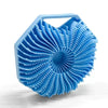 A light blue silicone exfoliating shower scrub brush with a textured, fan-like head.