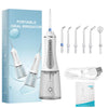 A portable oral irrigator device in a clear plastic bottle with various attachments and a charging cable.
