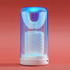 A clear electric toothbrush with a glowing blue light is displayed on a pink background.