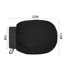 Gant pour gommage corporel noir avec sangle et élastique, montré à plat.