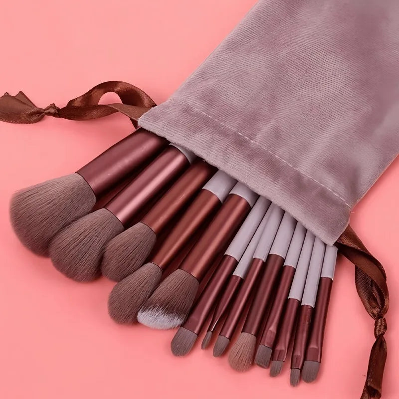 A collection of 15 makeup brushes with brown and gray handles and bristles, tied with a brown ribbon.