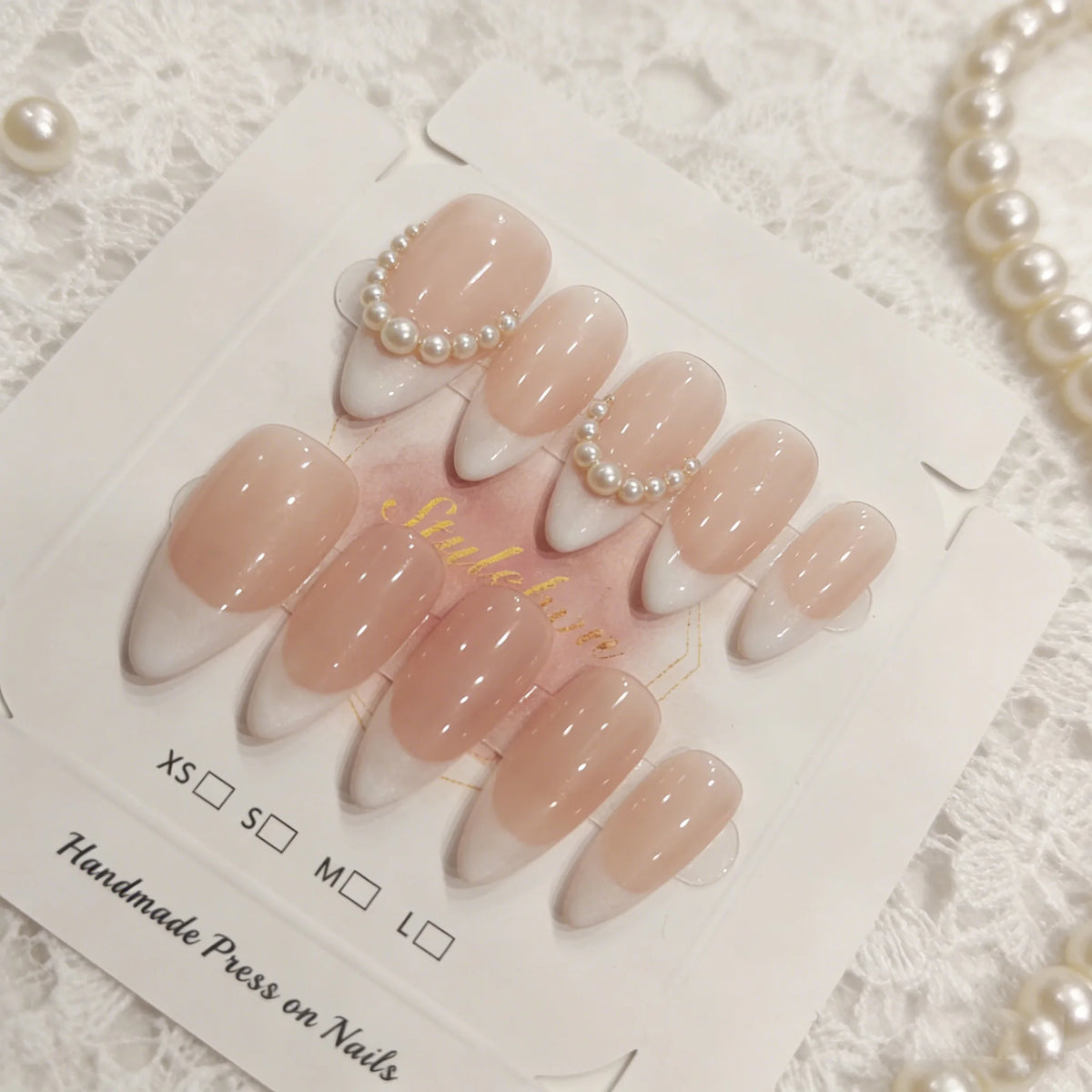 Pink handmade press-on nails with a sheer pink and white gradient finish displayed on a card.