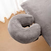 A gray reusable U-shape pillow cover used for massage or beauty treatments.