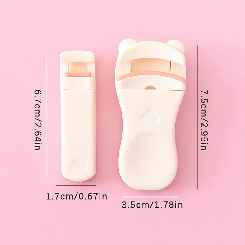 A white cartoon mini eyelash curler shown against a pink background with dimension measurements.
