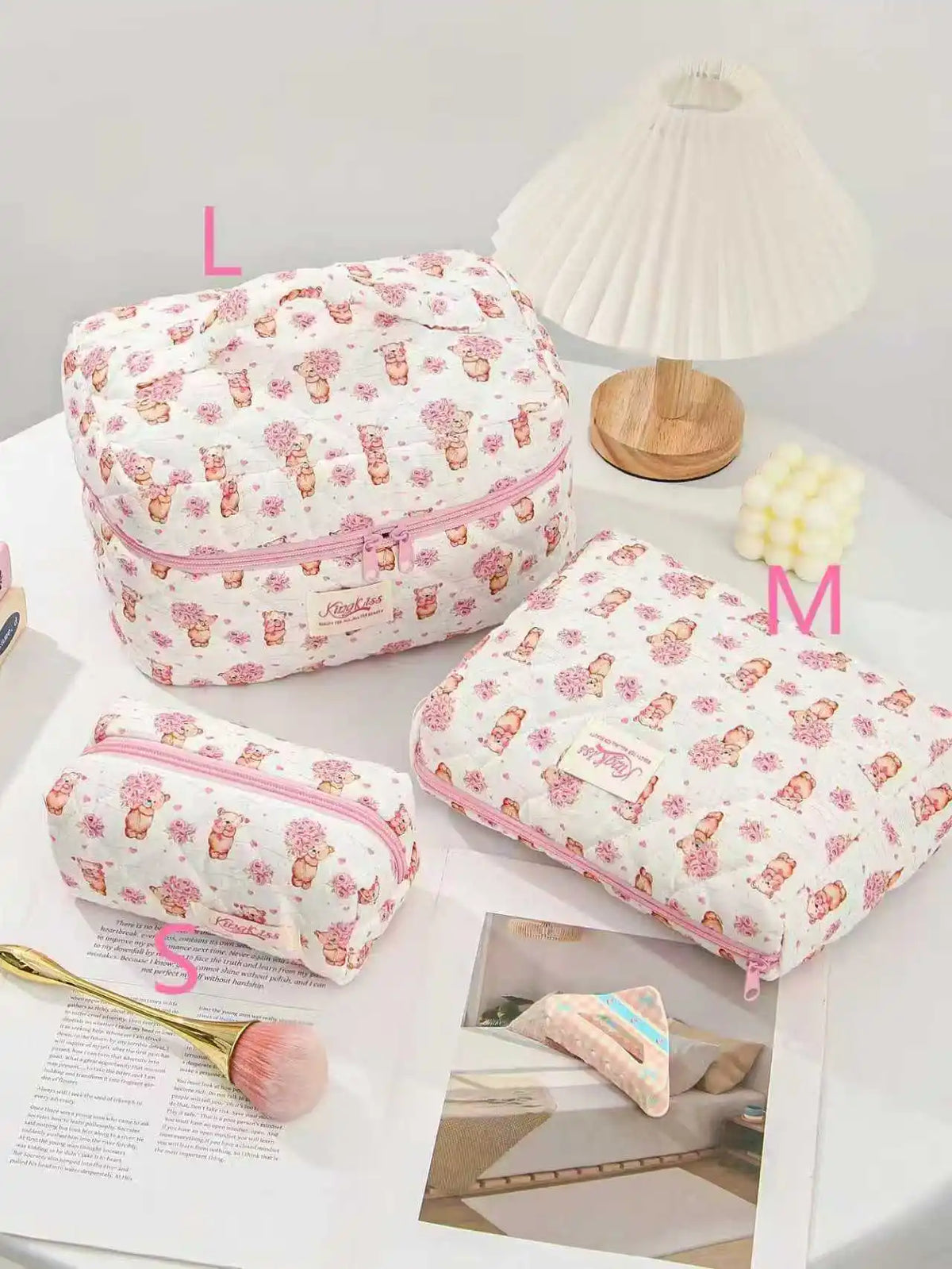 A pink quilted cotton makeup bag with a floral pattern is shown next to a lamp and a makeup brush.