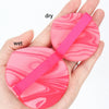A hand holds a pink beauty puff set, showing both dry and wet versions.