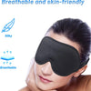 A close-up of a black 3D contoured sleep mask being worn on a person's eye area.