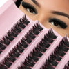 Close-up of a person's eye showing a set of black false eyelashes on a pink plastic tray.