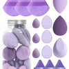 A collection of 15 purple makeup sponges and applicators in various shapes and sizes displayed next to a glass jar.