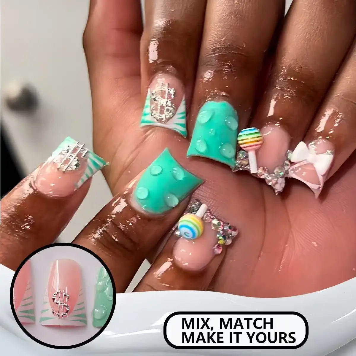 A close-up of a hand displaying various colorful and glittery press-on nails with various designs and charms.