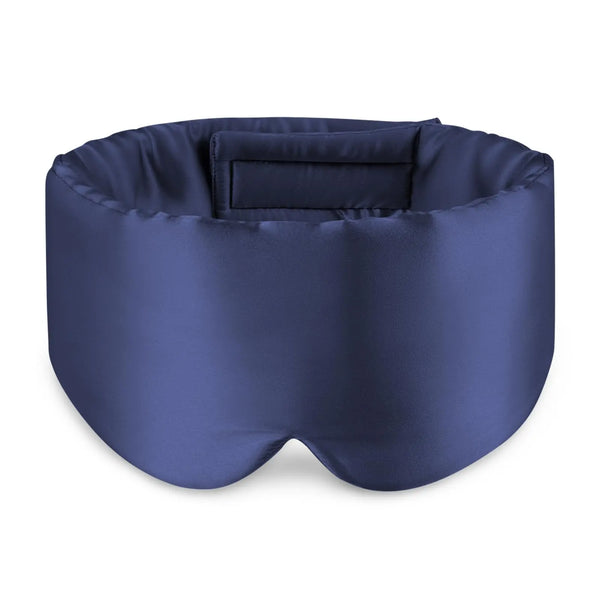 A navy blue silk sleeping eye mask with a padded design.