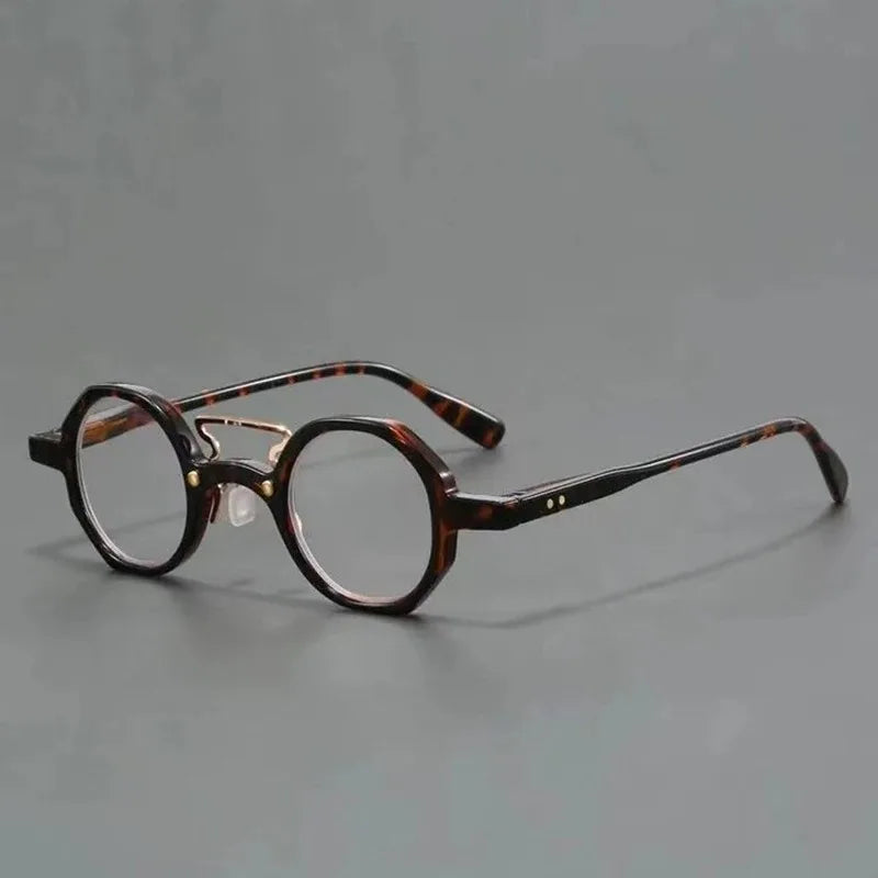 Une paire de lunettes rondes écaille de tortue posées sur une surface grise.