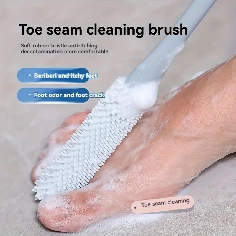 A close-up of a white toe seam cleaning brush being used on a foot to remove dead skin and odor.