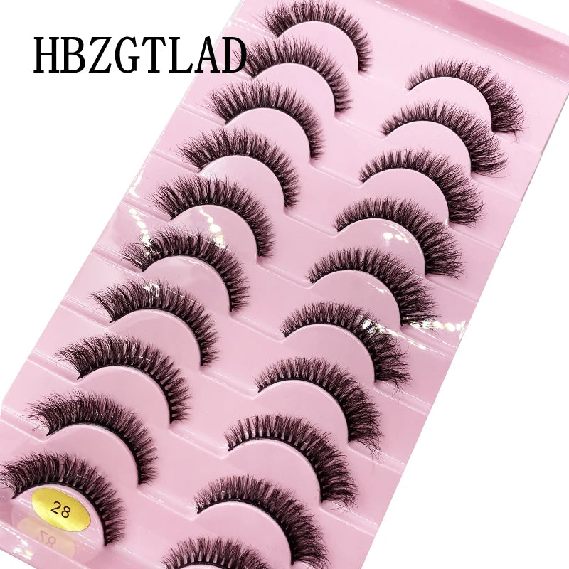 Plateau en plastique rose contenant divers styles de faux cils de renfort mink pour application.