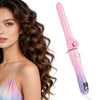 A pink automatic rotating hair curler is shown next to a woman with long brown wavy hair.