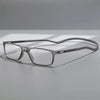 A pair of silver-framed reading glasses with mirror lenses resting on a light gray surface.