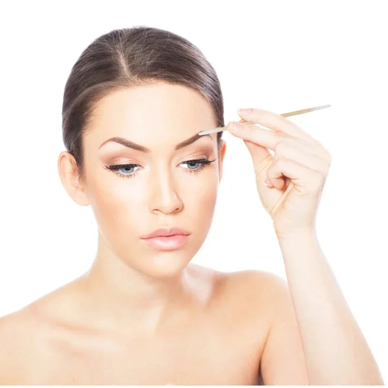 Une femme applique du maquillage avec un coton-tige près de son œil.