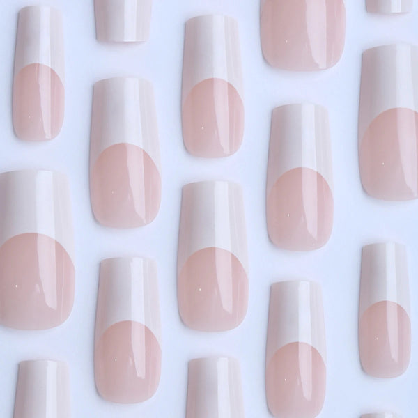 A collection of 24 press-on nails in a milky pink and white gradient with coffin shape tips.