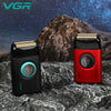 A pair of VGR electric beard and mustache trimmers, one black and one red, resting on a dark, textured rock surface.