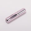 A silver metallic portable refillable perfume bottle with a cylindrical shape.