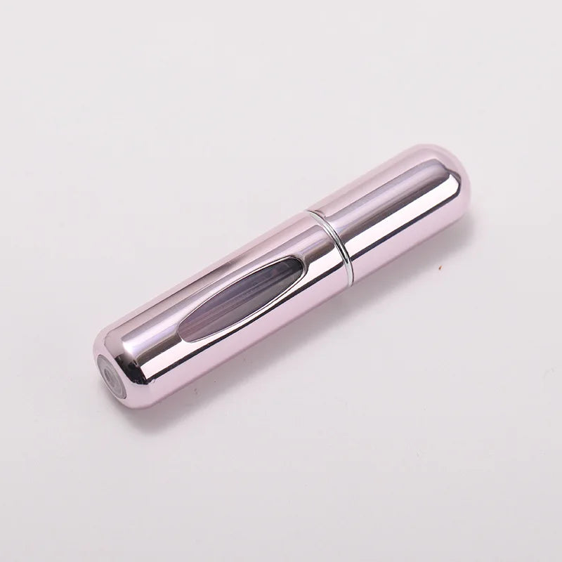A silver metallic portable refillable perfume bottle with a cylindrical shape.
