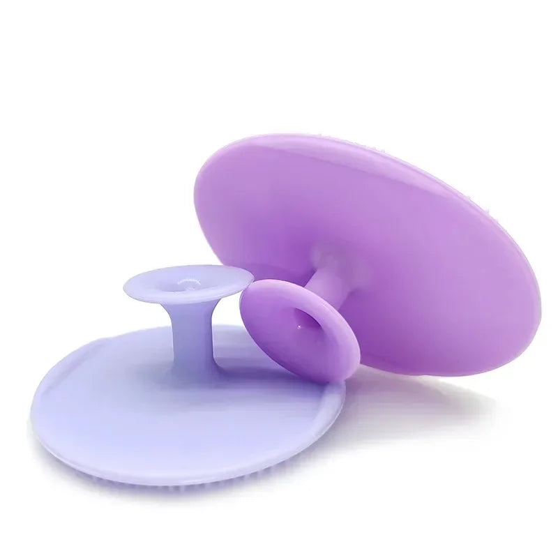 Purple silicone facial cleansing brush with a flat base and a rounded head.