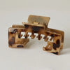 A close-up of a tan and brown leopard print non-slip hat claw clip with a gold-colored pin.