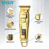 A gold-colored professional cordless electric hair clipper with stainless steel blades and USB charging port.