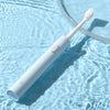 A white sonic electric toothbrush with a brush head is shown floating in clear water.