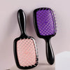 A pair of black hair combs with purple and pink bristles shown against a light background.