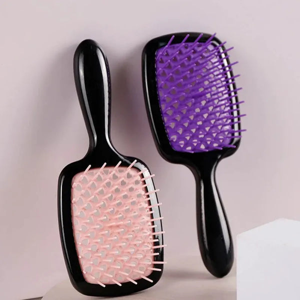 A pair of black hair combs with purple and pink bristles shown against a light background.