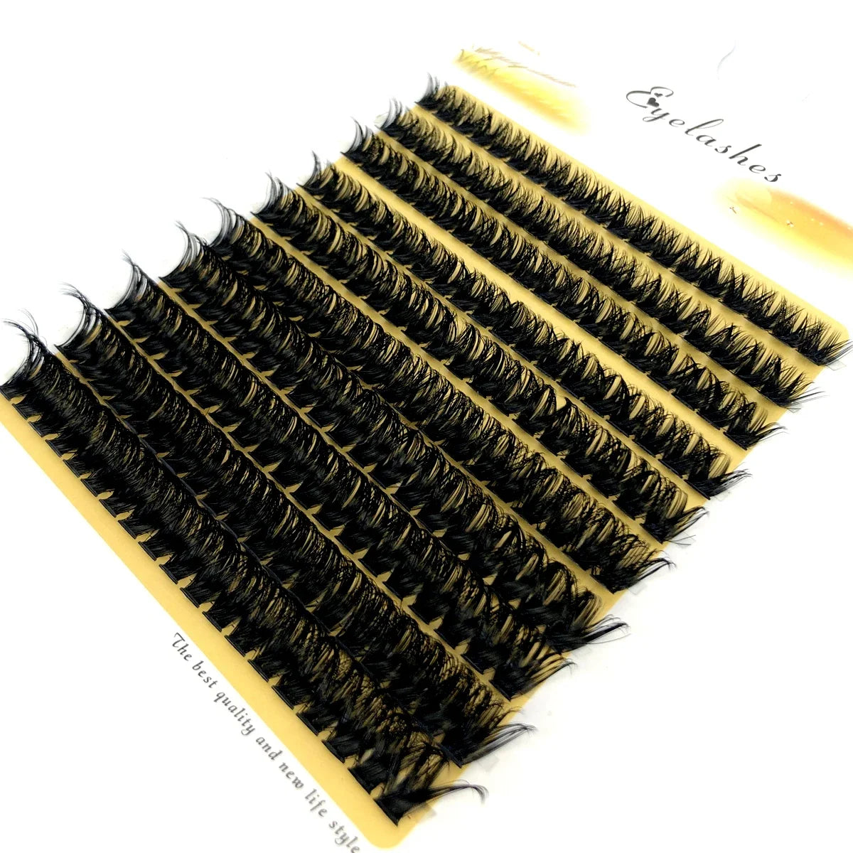 A fan-shaped cluster of black mink eyelashes displayed on a yellow background.