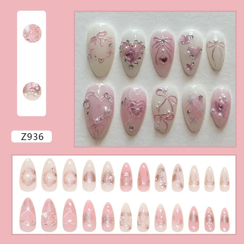A collection of 24 pink heart pearl press-on fake nails displayed on a white background.