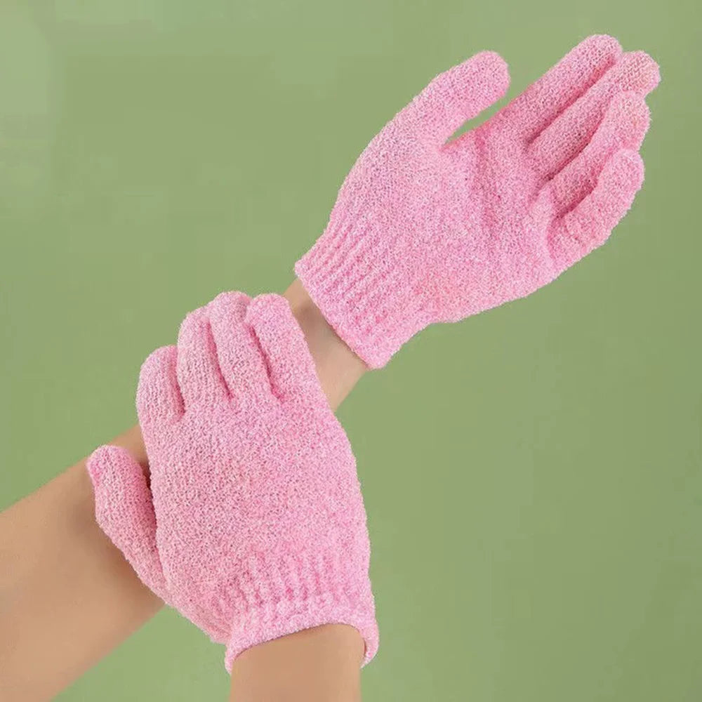 A close-up of pink exfoliating mitts for body massage worn on a person's hand and wrist.