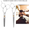 A pair of silver barber scissors and thinning shears shown next to a man getting a haircut.