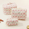 A collection of pink and white quilted cotton makeup bags with floral embroidery displayed on a light background.