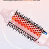 A pink heated round hair brush with red light-emitting tips is shown applying infrared light to hair strands.