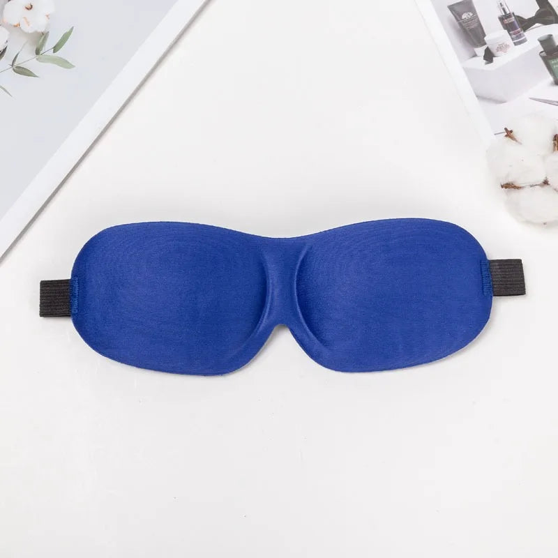 A royal blue comfortable 3D sleep mask for light blocking lying on a white surface.