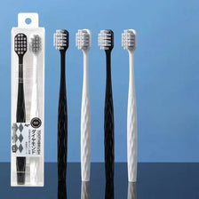 Un set de cinq brosses à dents antibactériennes blanches et noires dans un emballage plastique transparent.