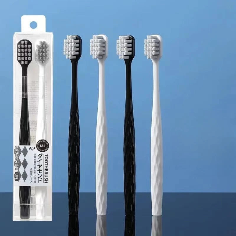 Un set de cinq brosses à dents antibactériennes blanches et noires dans un emballage plastique transparent.