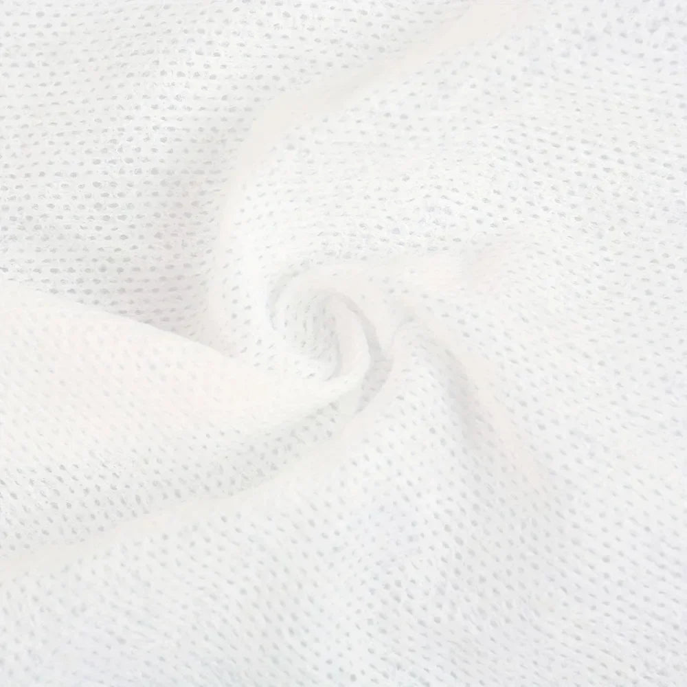 A close-up of white reusable compressed face towels made of a textured, absorbent fabric.