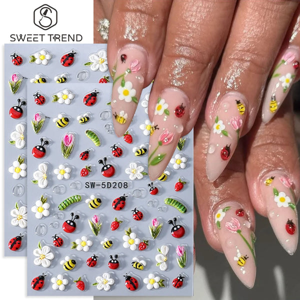 Close-up of a hand displaying floral and insect nail art stickers on fingernails.