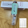 A portable electric oral irrigator device in light mint green and silver, shown next to its packaging and included flossers.