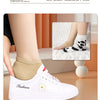 White fashion sneakers with silicone heel protectors shown on a person's foot.