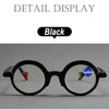 Gafas de lectura negras con lentes transparentes mostradas contra un fondo blanco.