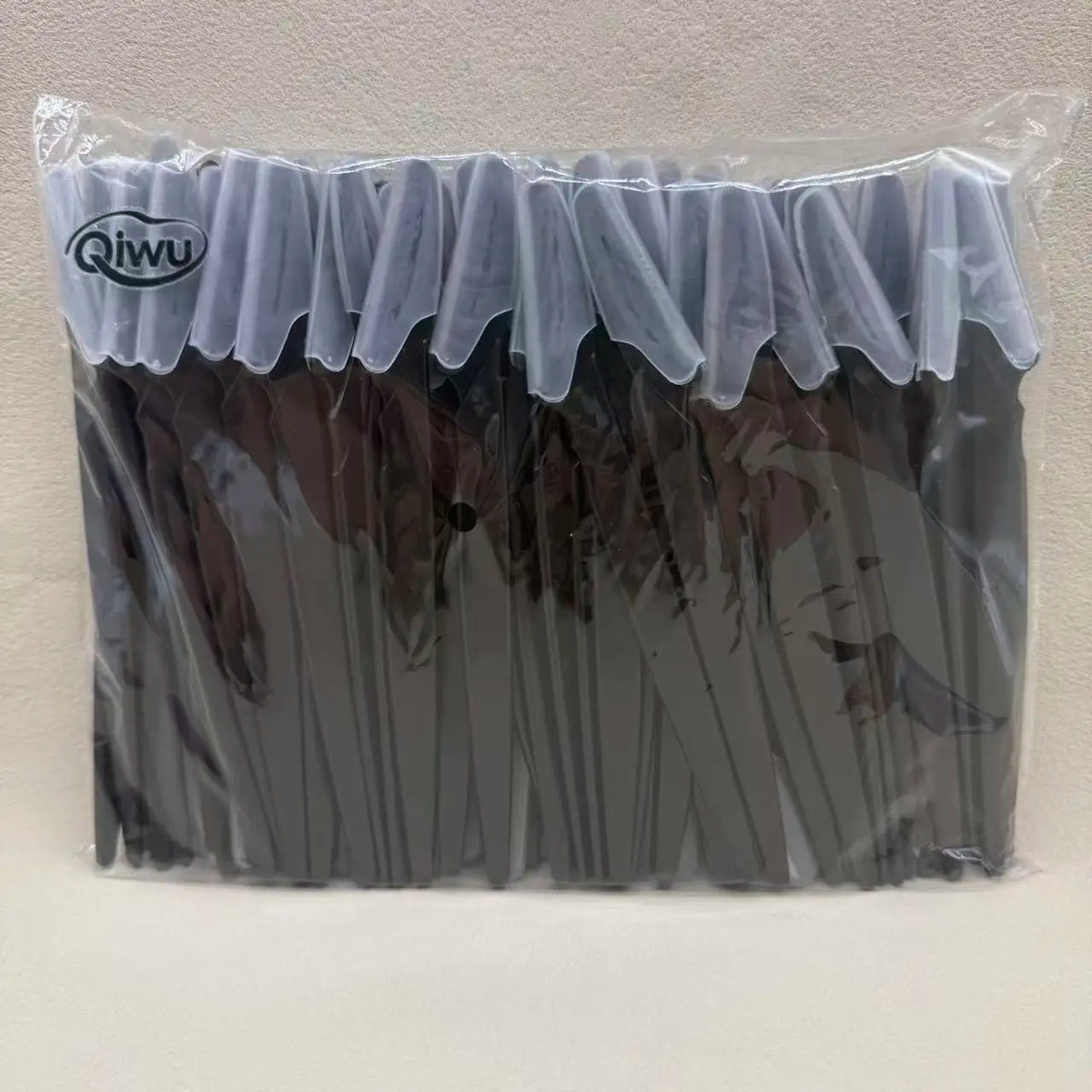 Un sac en plastique transparent contenant un ensemble de ciseaux à sourcils de précision avec des poignées sombres et des pro
