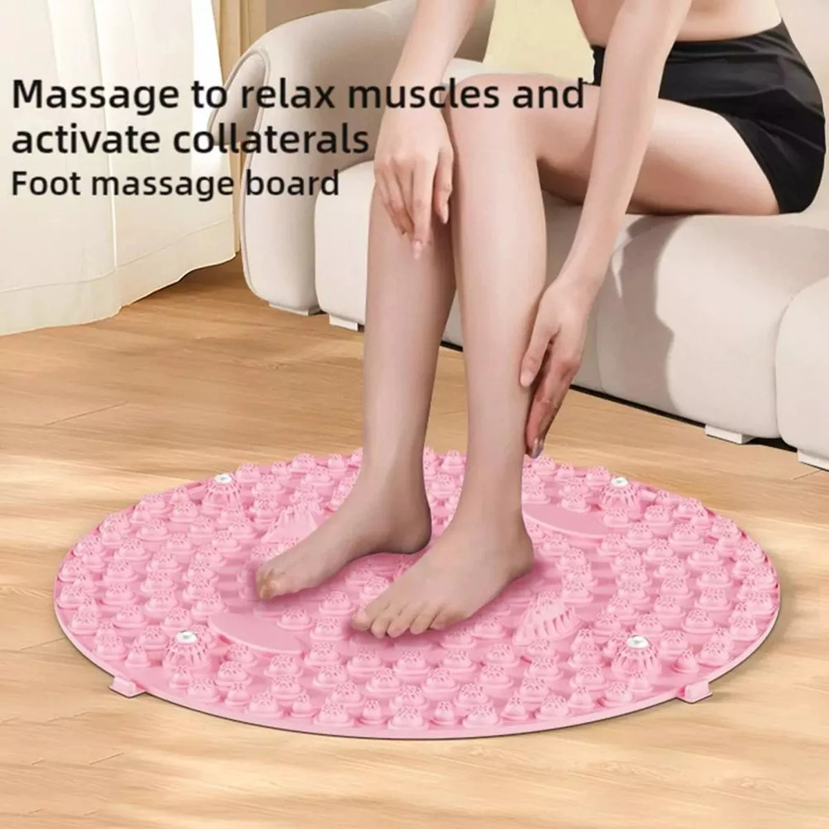 A woman is using a pink magnetic foot massage board on a wooden floor.